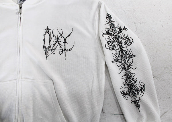 White hoodie with black floral designs on a light gray background