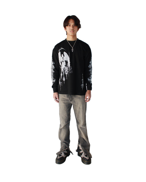 Person wearing a black long-sleeve shirt with a graphic design and gray pants on a white background