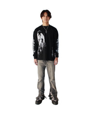 Person wearing a black long-sleeve shirt with a graphic design and gray pants on a white background