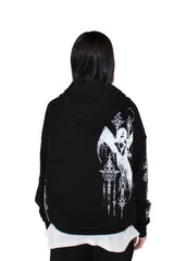 Person wearing a black hoodie with a white graphic design on the back against a plain background