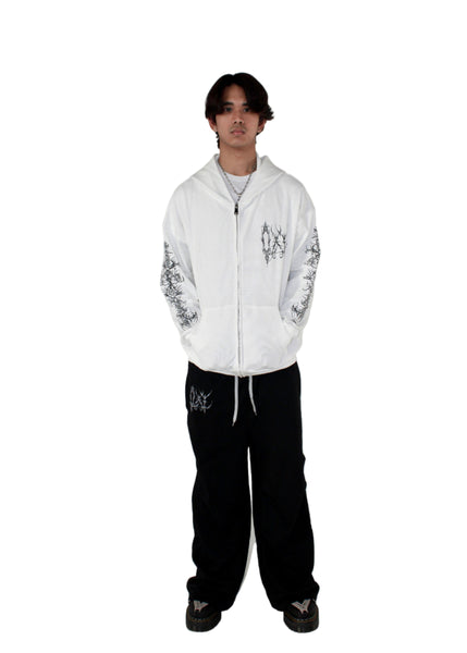 Person wearing a white hoodie with black designs on a white background