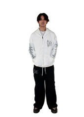 Person wearing a white hoodie with black designs on a white background