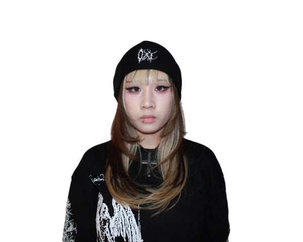 Person wearing a black beanie and black outfit with white designs on a white background