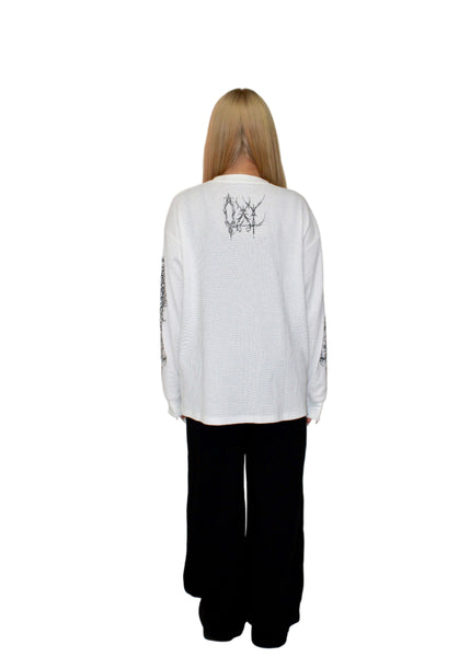 Person wearing a white long-sleeve shirt with text on the back against a plain background