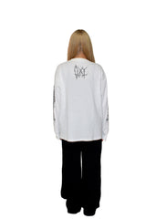 Person wearing a white long-sleeve shirt with text on the back against a plain background
