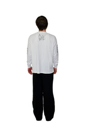 Person wearing a white long-sleeve shirt with text on the back against a plain background
