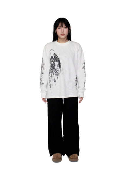 Person wearing a white sweatshirt with black graphics and black pants on a white background