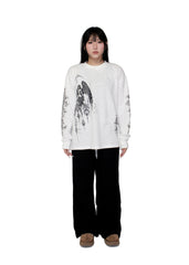 Person wearing a white sweatshirt with black graphics and black pants on a white background