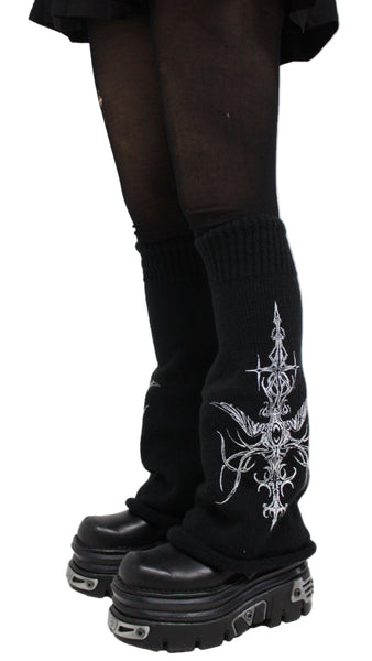 Black knee-high boots with white embroidery on a white background