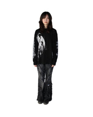 Person wearing a black sweater with a white design on a white background
