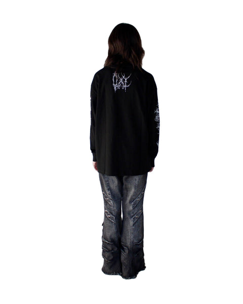 Person wearing a black jacket with a logo on the back against a white background