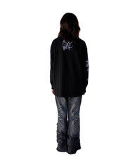 Person wearing a black jacket with a logo on the back against a white background