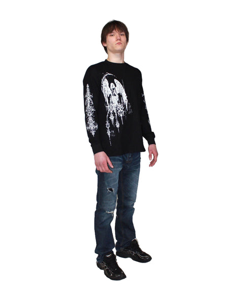 Person wearing a black long-sleeve shirt with white graphic design and blue jeans on a white background