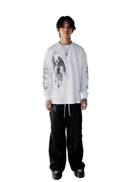 Person wearing a white long-sleeve shirt with black patterns and black pants on a white background