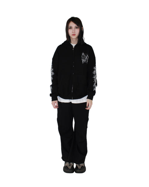 Person wearing a black jacket with white designs on a white background