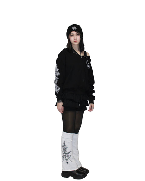 Person wearing a black outfit with white patterns on a plain background