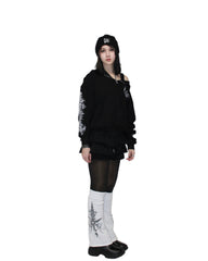 Person wearing a black outfit with white patterns on a plain background